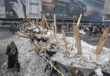 A woman walks near a barricade at the main street Khreschatyk where pro-European integration protesters hold a rally in central Kiev